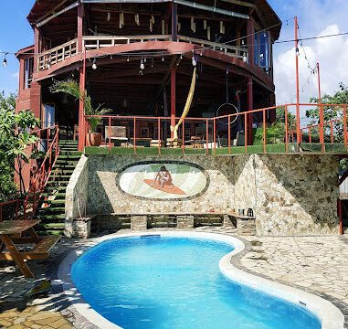 View of Magnific Rock Surf Resort & Yoga Retreat with pool and frontage of the building.