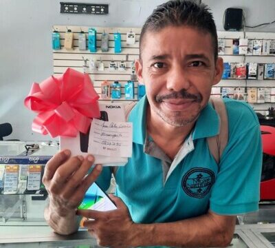 Technician repairing mobile phones at Tel Cell San Juan Del Sur with accessories displayed on the counter