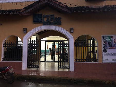 Photo of Medina's Cell storefront in San Juan del Sur showing glass display with phone cases, chargers, and mobile accessories