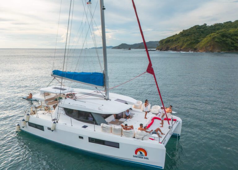 Santana Sail Nicaragua Primer plano de un yate con el logotipo de Santana Sail y personas a bordo en el agua